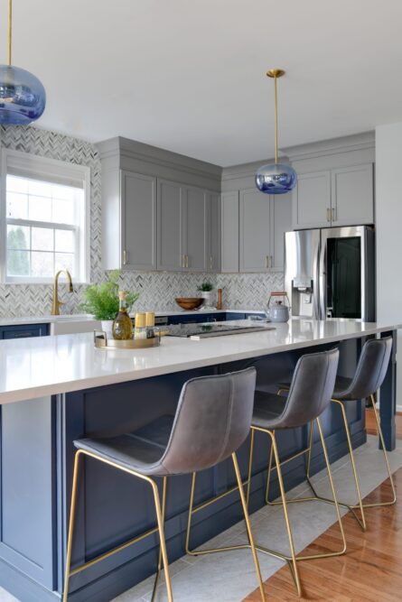 Photo of a kitchen design project in Ashburn VA featuring a soothing gray and blue color palette and a custom island with comfortable seating for six
