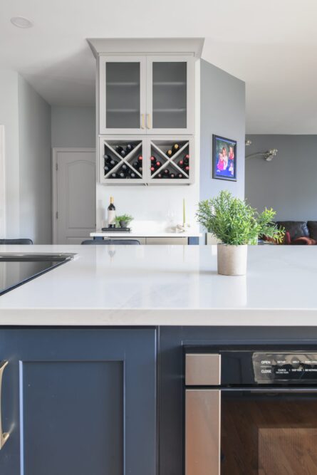 Photo of a kitchen design project in Ashburn VA featuring a soothing gray and blue color palette and a customized wine storage solution